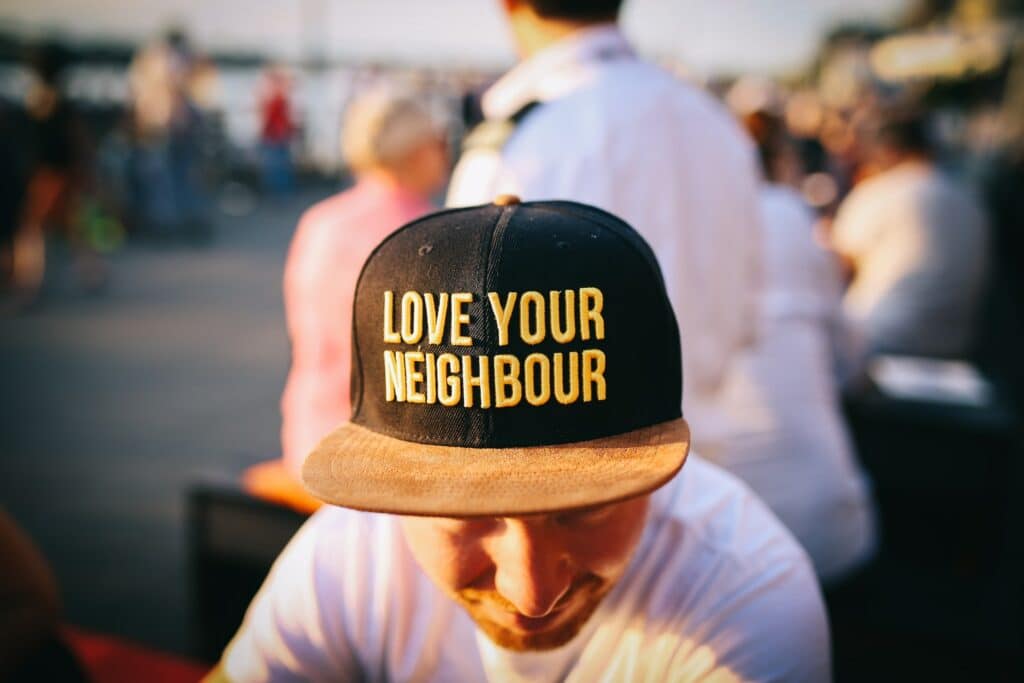 Man with love your neighbour hat